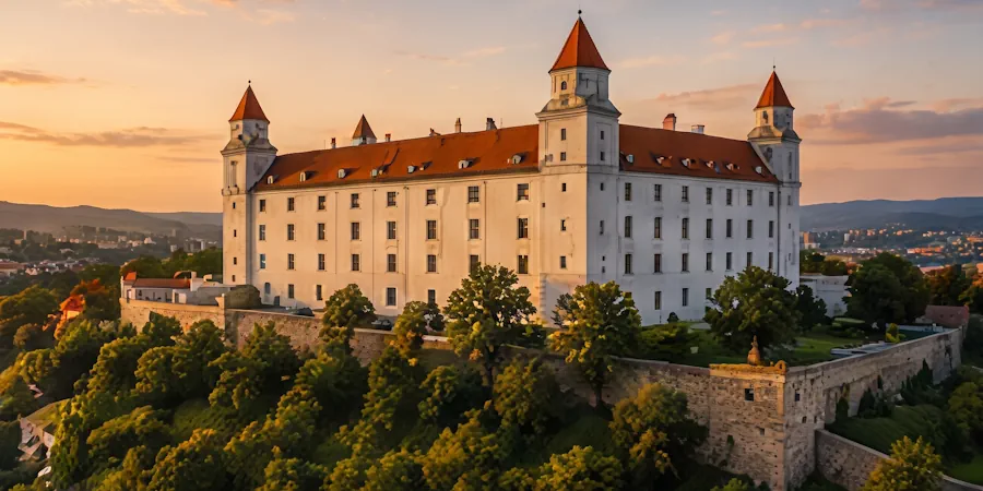 Bratislava Castle on its hill above green parkland at sunset